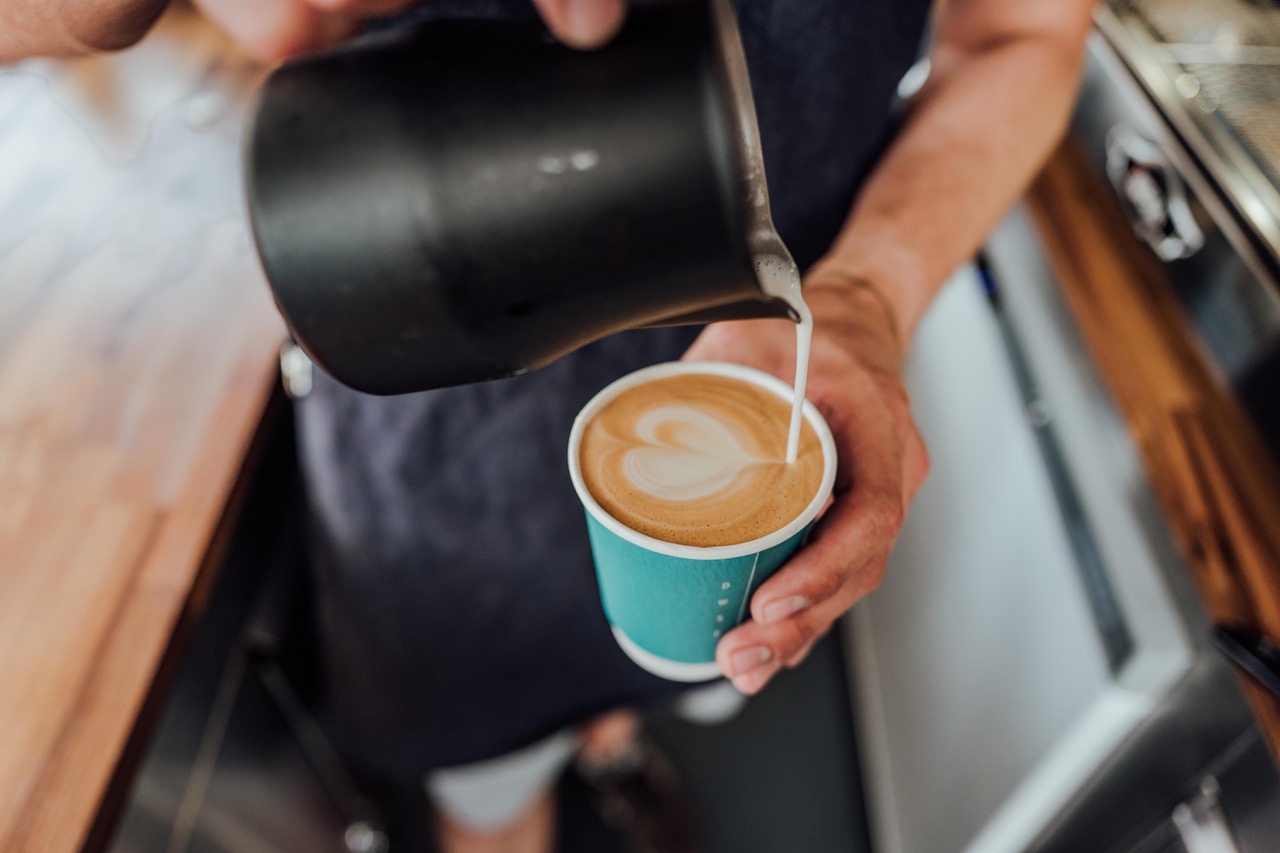 Barista bei der Zubereitung von Latte Art